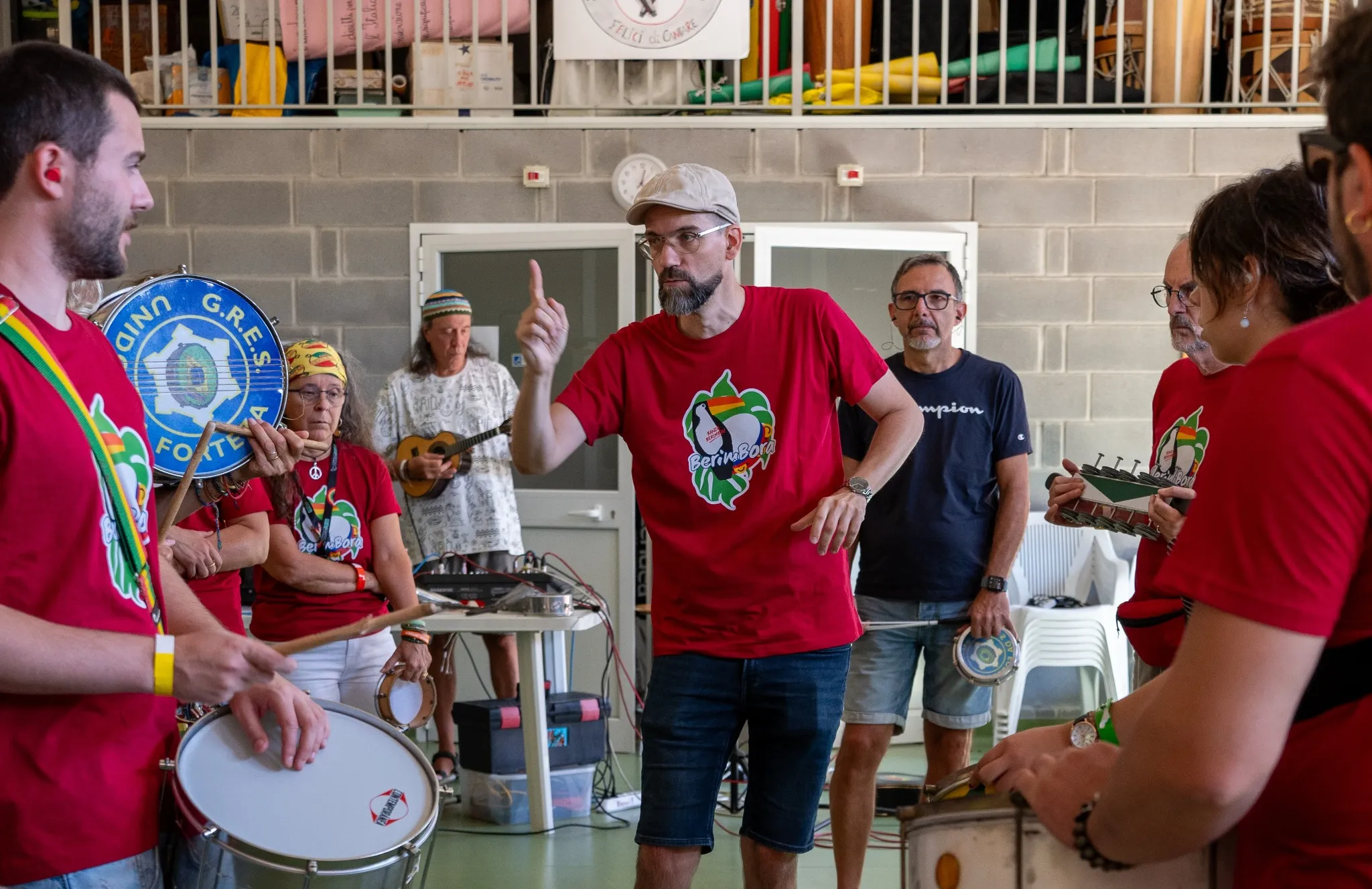 Chris Quade Couto gibt einer Percussiongruppe mit erhobenem Zeigefinger ein musikalisches Zeichen